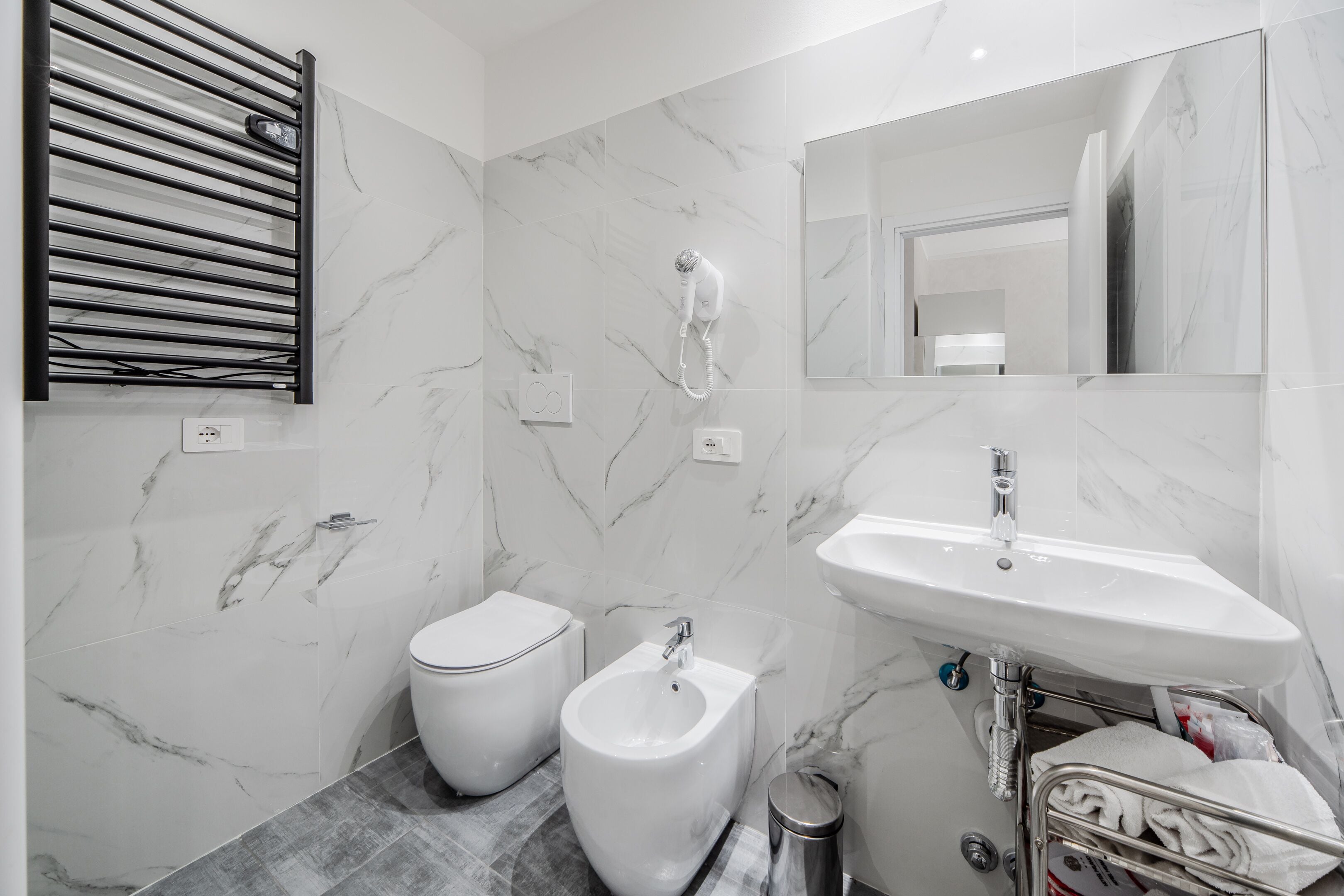 A modern bathroom with a bidet, toilet, and sink.