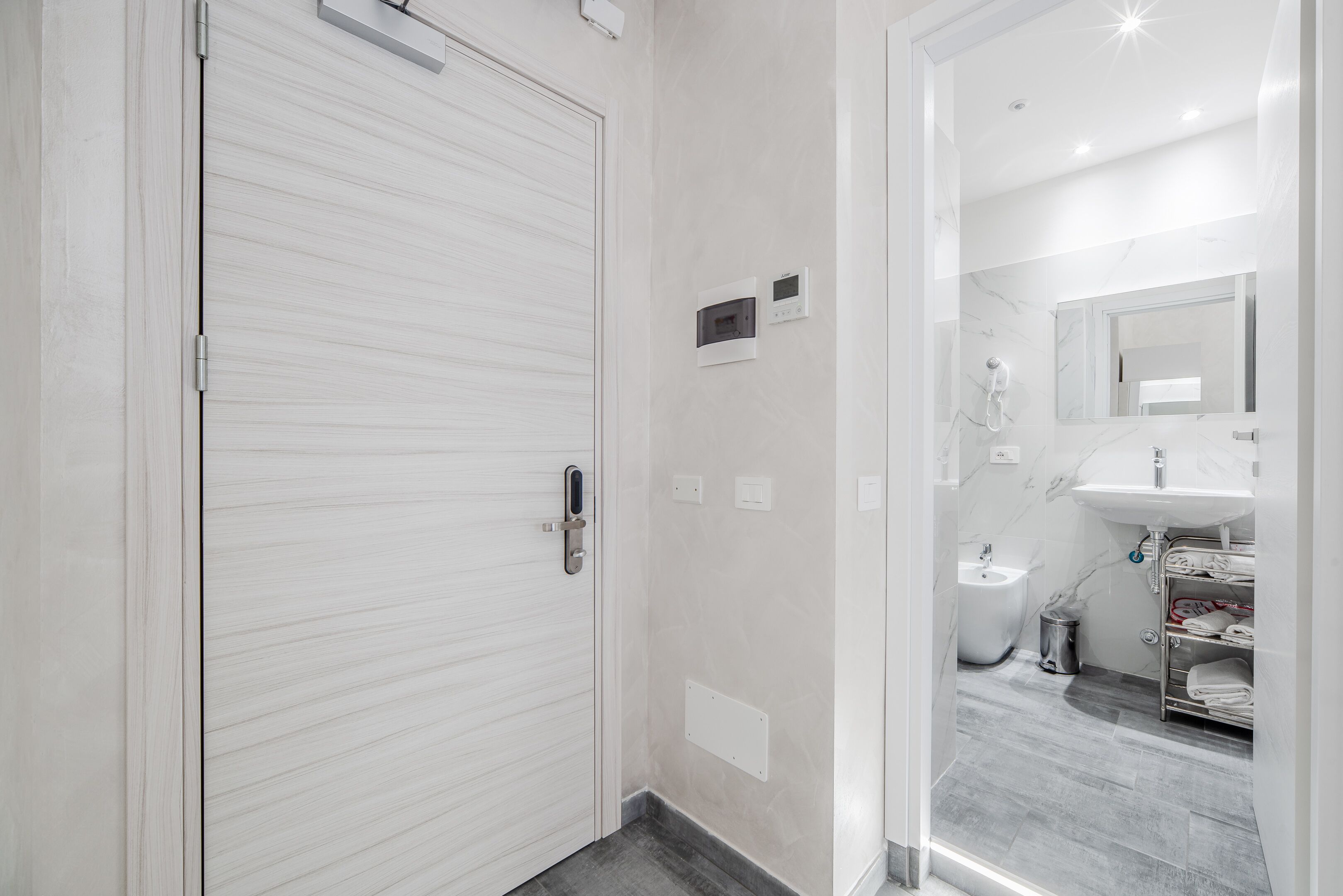 Een moderne badkamer met toilet, bidet en een douchecabine met glazen wanden.