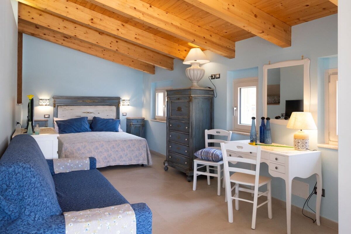 A bedroom with a bed, a dresser, a desk, and a chair.
