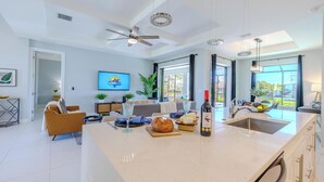 A spacious kitchen with a large island, modern appliances, and a view to the outdoors. - Sleeps 8 - Heated Pool - Games - Quiet area - Stars Vacation Rentals (Cape Coral)