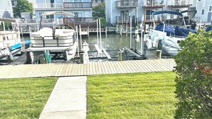 Un port de plaisance avec des bateaux amarrés, une zone herbeuse et des immeubles résidentiels en arrière-plan.