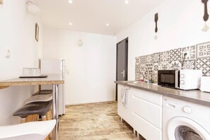 A compact kitchen with a microwave, toaster, and a washing machine. - Chambre Saint Pierre - Hypercentre - Gaillac (Gaillac)