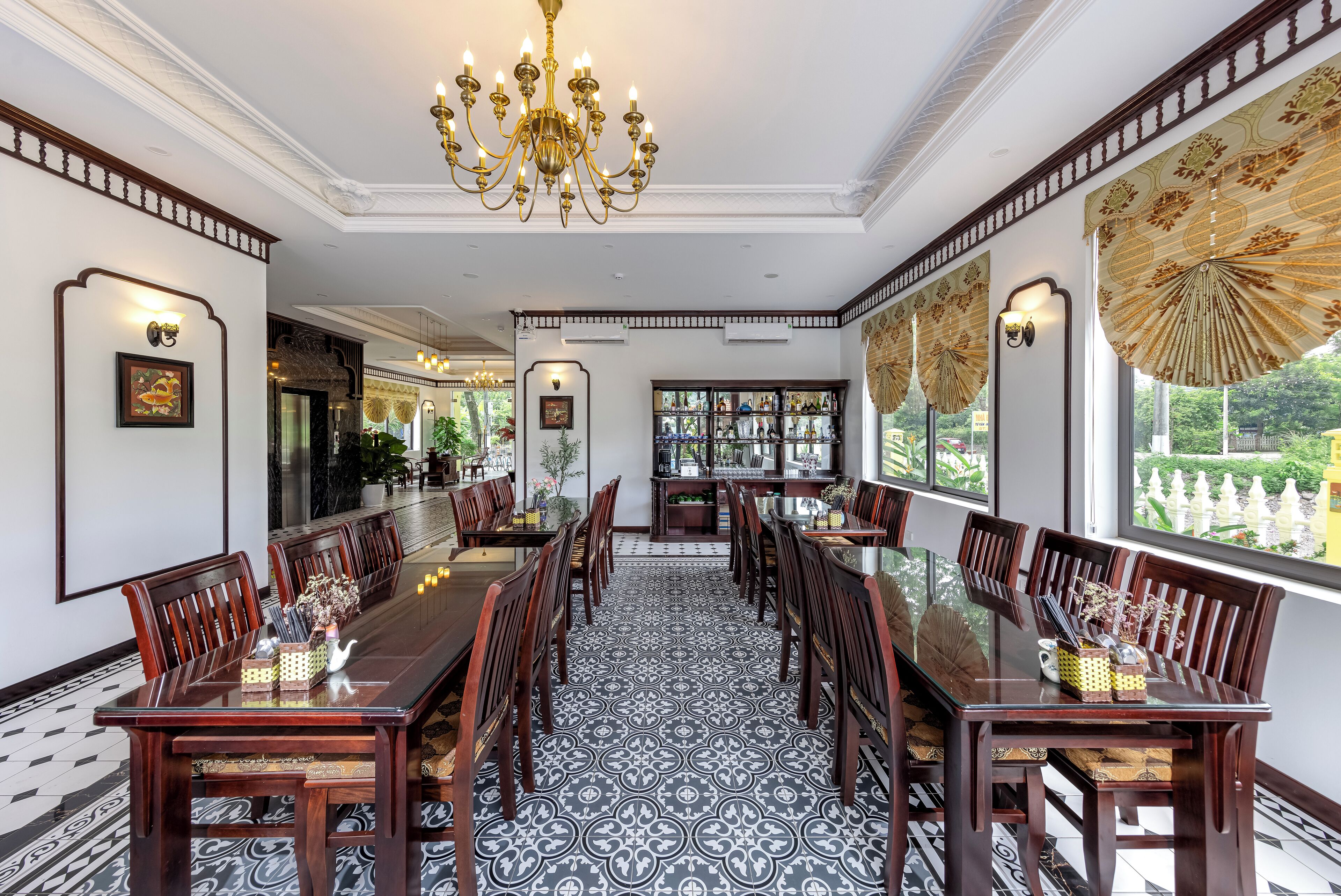 A formal dining room with a long table, chairs, and a chandelier.