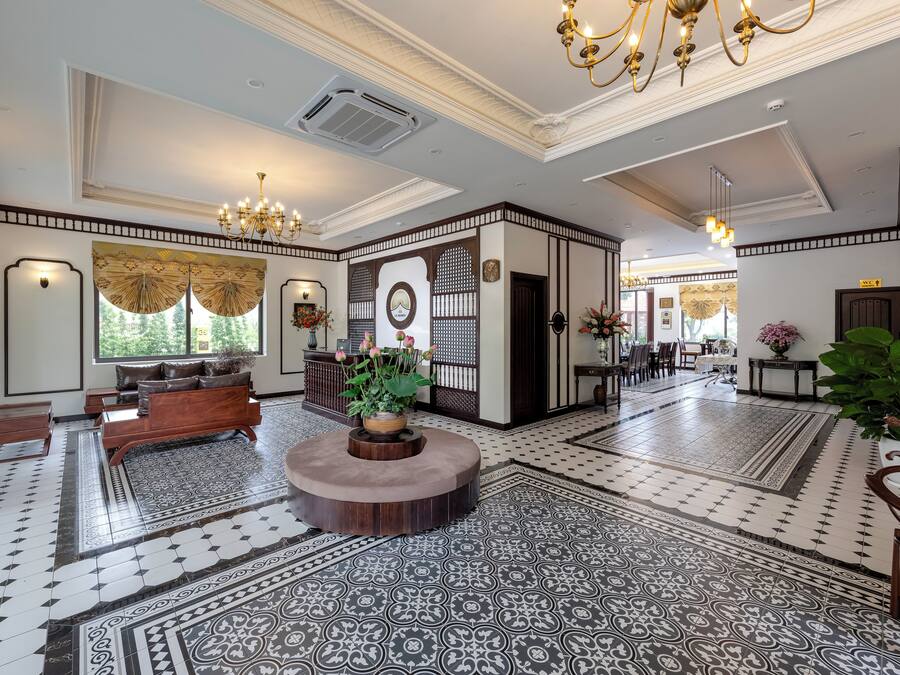 A spacious lobby with a central seating area, patterned flooring, and a decorative wall with a clock.