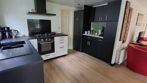 A compact kitchen with a stove, oven, and modern cabinetry.