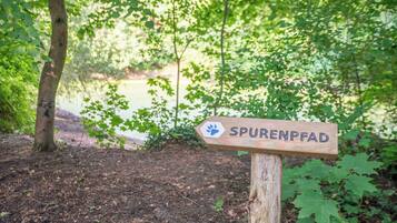 Een houten bord met de tekst 'SPURENFAD' en een pootafdruk symbool.