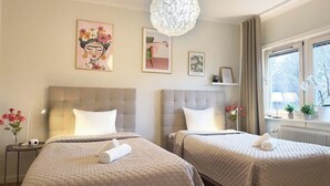 Habitación de hotel con dos camas, un ventanal con vistas y un candelabro.