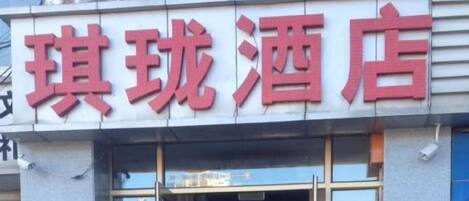 A hotel sign with red lettering on a white background.