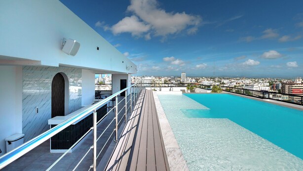 A rooftop pool with a city view, a white building with marble walls, and a clear blue sky. - Luxury, pool, gym in the city center (Distrito Nacional)