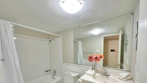 Une salle de bain équipée d’une baignoire, de toilettes, d’un lavabo et d’un miroir.