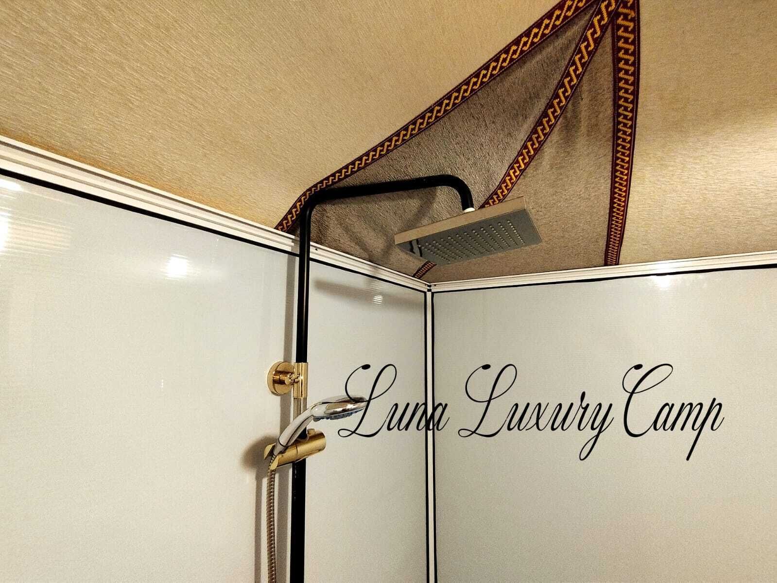 A bathroom with a shower, a towel rack, and a door with a lock.