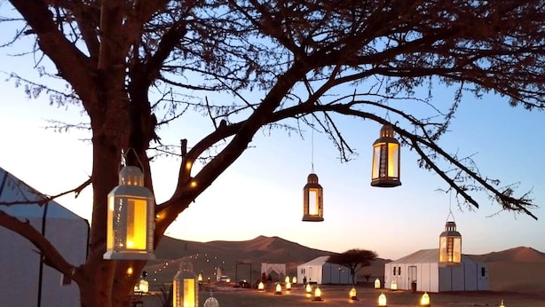 A desert setting with tents and lanterns. - Luna Luxury Camp (Rissani)