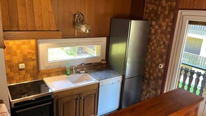 A compact kitchen with a built-in oven, a sink, and a refrigerator.