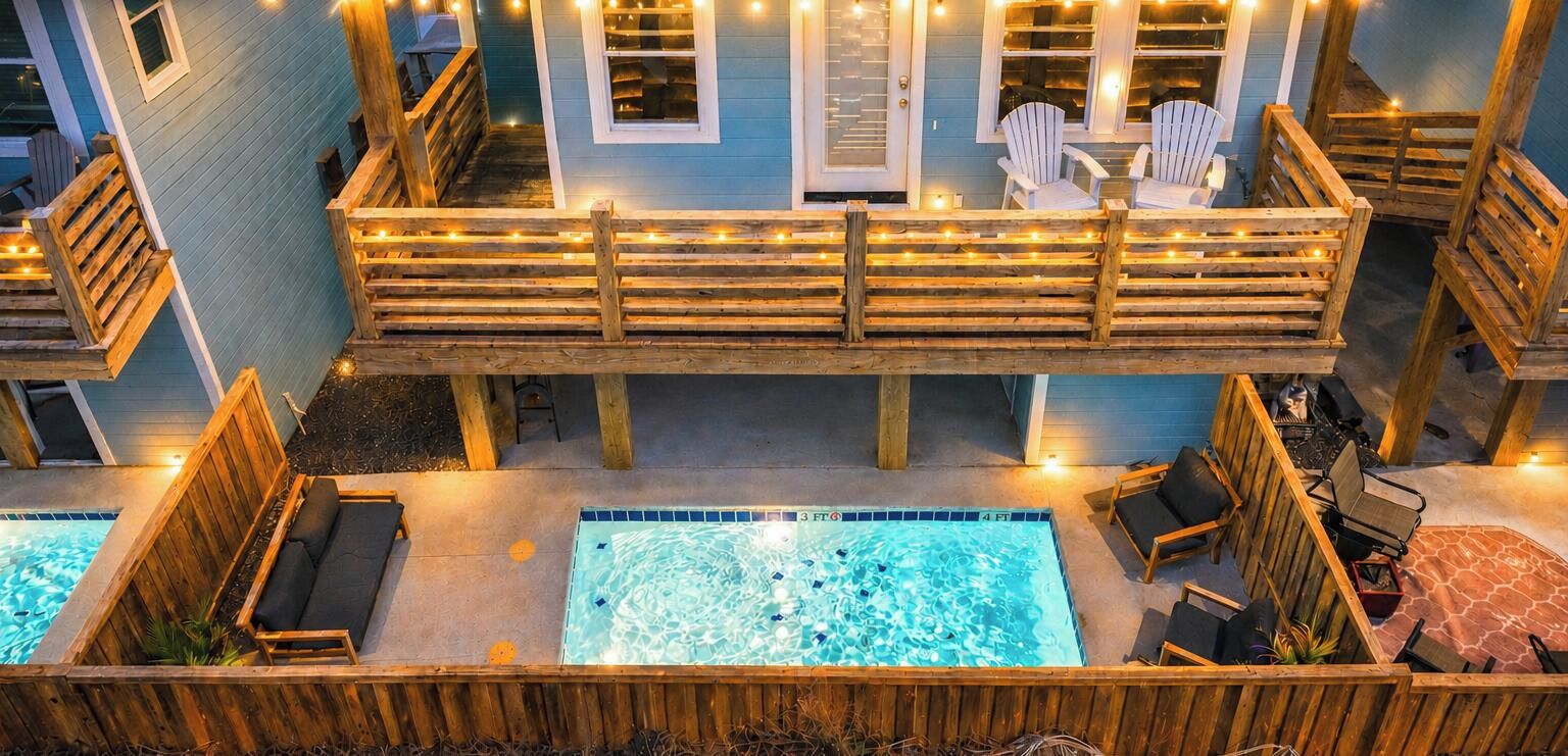 Área de piscina com espreguiçadeiras de madeira e banheira de hidromassagem.