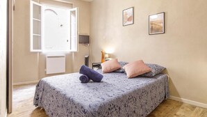 A bedroom with a bed, a window, and two wall-mounted pictures. - Chambre Portal - Hypercentre - Gaillac (Gaillac)