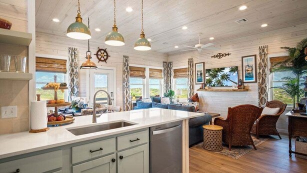A spacious kitchen with a large island, pendant lighting, and a view of the outdoors. - Jetty Set Go! Ocean Views & Private Pool! (Port Aransas)