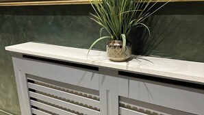 A reception desk with a potted plant, a cash register, and a payment terminal. -  Rest Inn Edmonton (London)