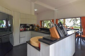 A modern kitchen with a central island, built-in appliances, and a view to the outdoors. - Villa Singkenken (Bali)