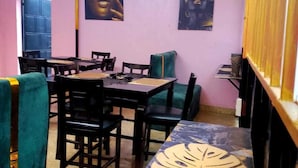 Un espace repas comprenant une table, des chaises et une fresque murale.