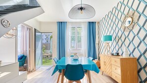 A modern dining room with a blue table, chairs, and a wooden cabinet. - La Halte Sainte-Catherine - Maison à 15min de la plage (Honfleur)
