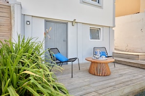 An outdoor seating area with two chairs and a table, surrounded by greenery. - La Halte Sainte-Catherine - Maison à 15min de la plage (Honfleur)