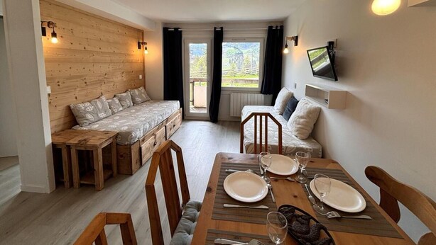 A cozy room with a wooden bench, a dining table set for two, and a TV mounted on the wall. - 150m from resort center, Ground floor, balcony, tv, 34m², Avoriaz (Avoriaz)