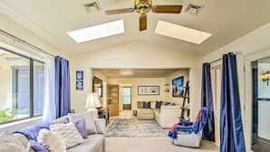 A spacious living room with a ceiling fan, a sofa set, a chair, and a view of the outside. - Cozy Cottage in the Heart of Lakeside (Lakeside)