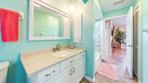 A bathroom with a sink, mirror, and towel rack.