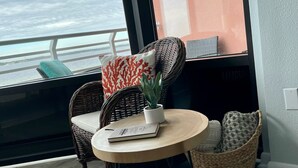A balcony with wicker furniture, a small round table, and a potted plant.