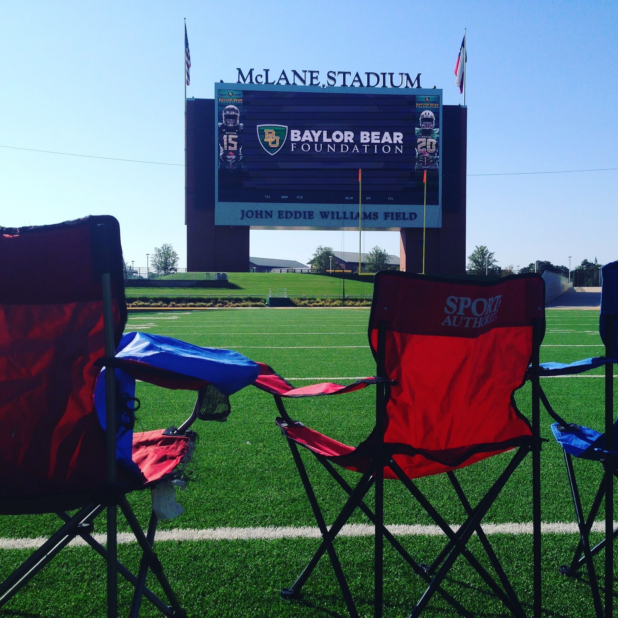 A stadium with a large digital scoreboard displaying the Baylor Bear Foundation logo and the name "John Eddie Williams Field".