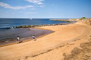 A sandy beach with a rocky breakwater and calm sea. - Sunnyside (Newbury)