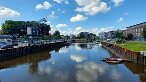 Um canal com barcos, uma ponte e edifícios em ambos os lados.