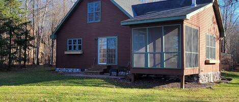 A two-story house with a large front porch and a satellite dish on the roof.