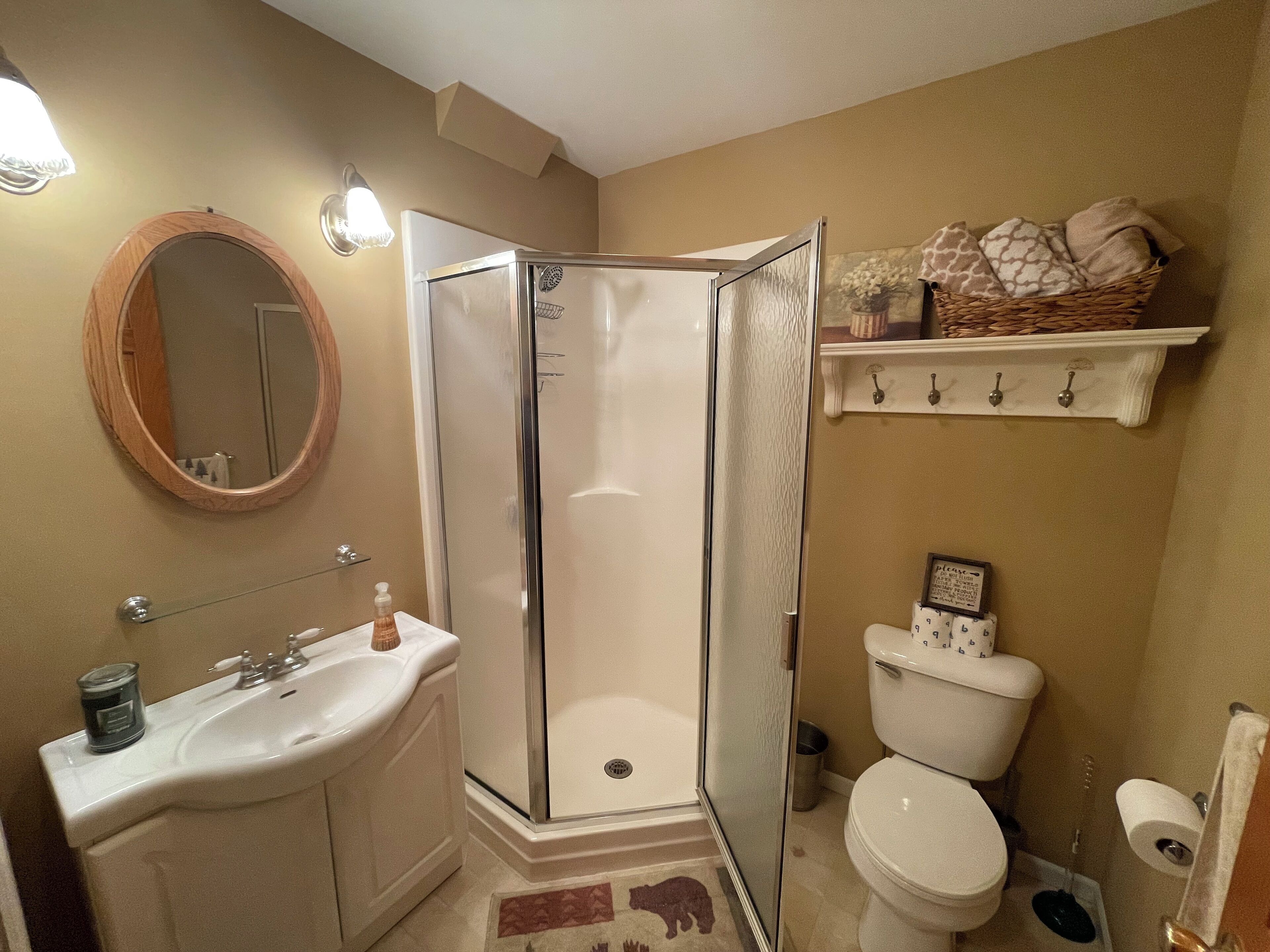 Ein Badezimmer mit Dusche, Waschbecken, Toilette und Spiegel.