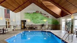An indoor swimming pool with a wooden ceiling, a mural of a landscape, and a flag. - Unit 109 2 Bdrm/ 2 BA (Birchwood)