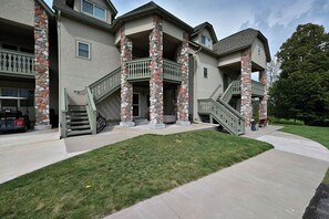 A multi-story house with stone pillars, a covered porch, and a front staircase.