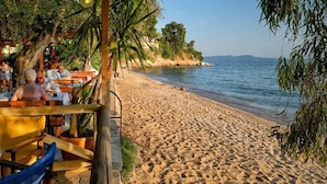 Ein Restaurant direkt am Strand mit Außenbereich und Meerblick.