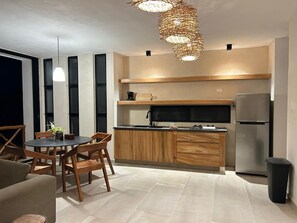 A modern kitchen with wooden cabinets, a built-in microwave, and a stainless steel refrigerator.