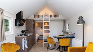 Un espacio habitable moderno y funcional con habitación en entrepiso, kitchenette y comedor.