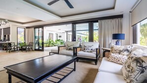 A spacious living area with a sofa, chairs, a coffee table, and a view of the outdoors. - 3-Bedroom Kejora 12 (Denpasar)
