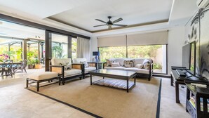 A spacious living room with a sofa, chairs, a coffee table, and a TV. - 3-Bedroom Kejora 12 (Denpasar)
