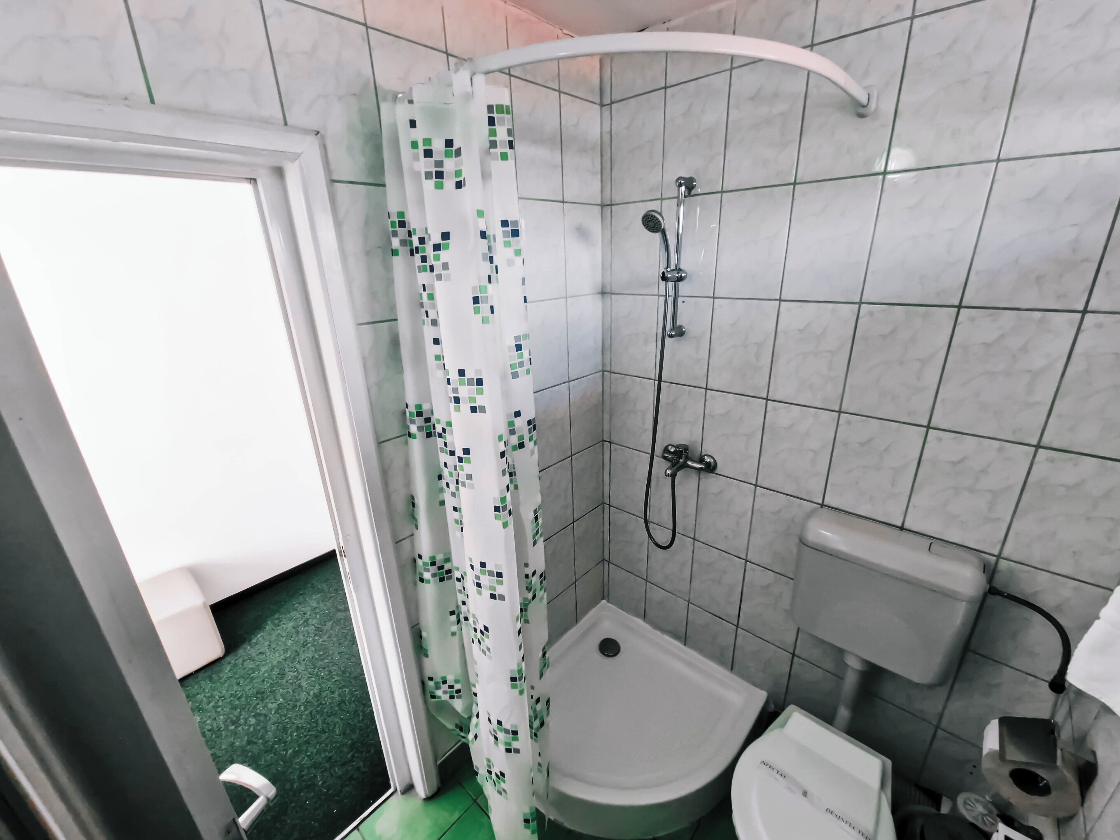 A bathroom with a shower, toilet, and sink.