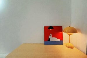 Ein Holztisch mit einem Gemälde und einer Lampe.