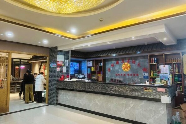 Un restaurante con mostrador, carteles de menú y un techo decorativo.