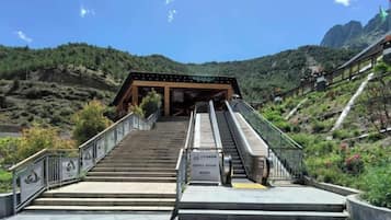 A staircase leading to a covered area with a view of a mountainous landscape.