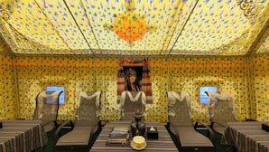 A room with a patterned yellow ceiling, a central table with a teapot, books, and a small box, flanked by two chairs. - Scenic Natural Hotel (Daocheng County)