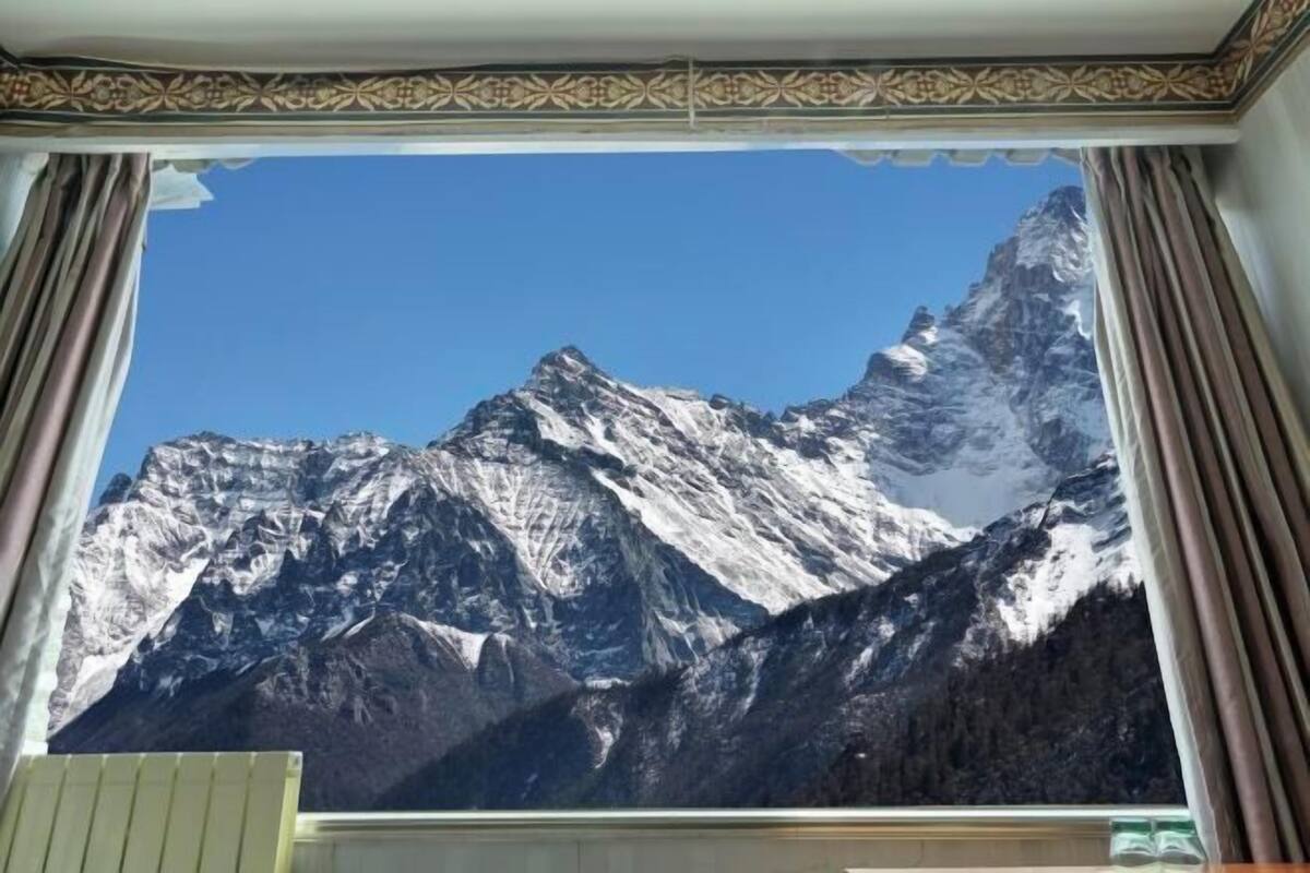 Una habitación con un amplio ventanal y vistas a un paisaje montañoso.