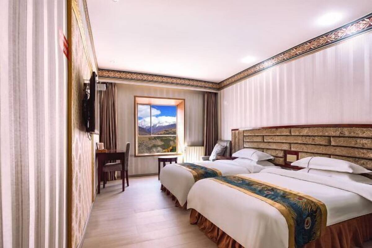 Una habitación de hotel con dos camas, un escritorio y una silla.