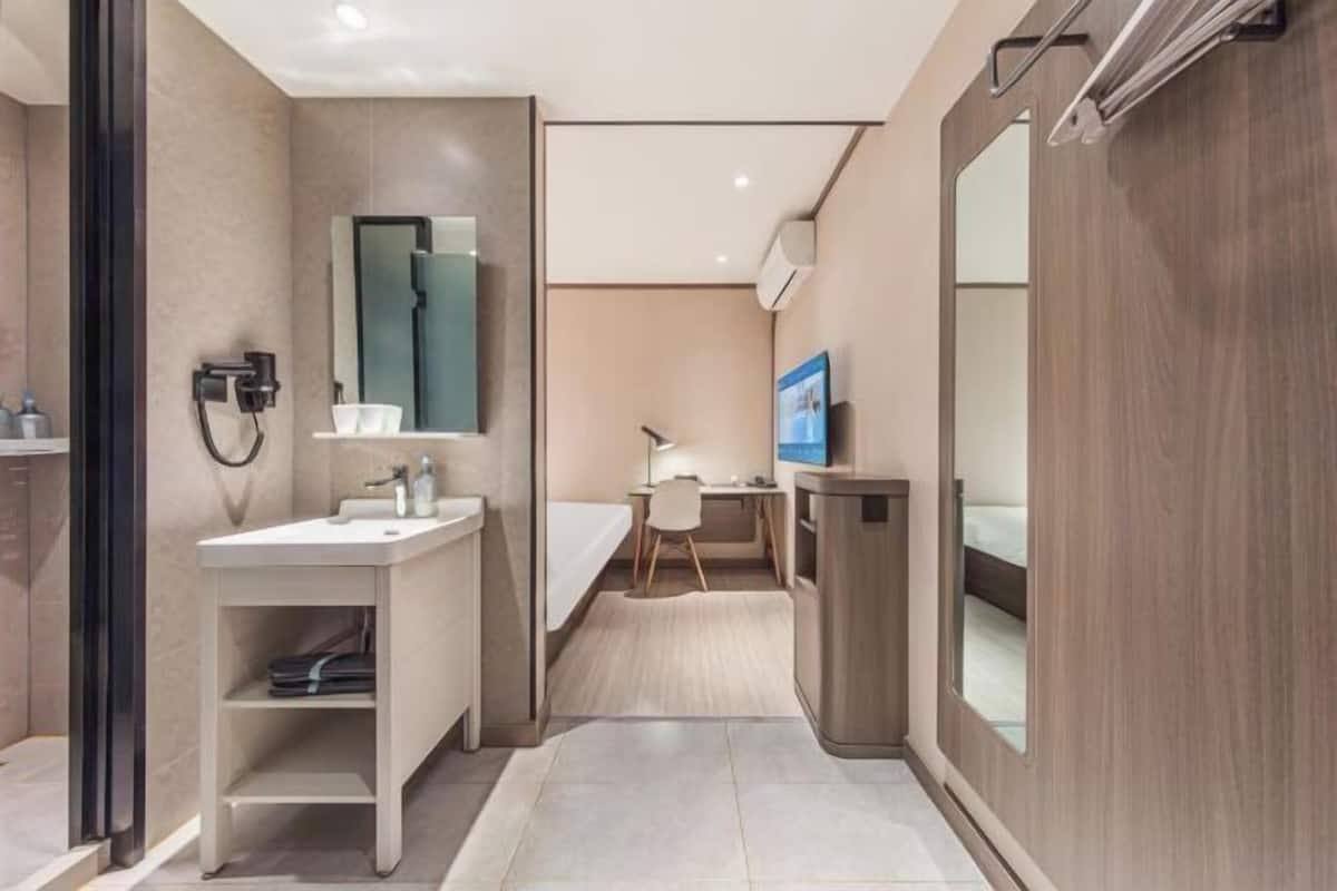 A modern bathroom with a sink, mirror, and toilet.