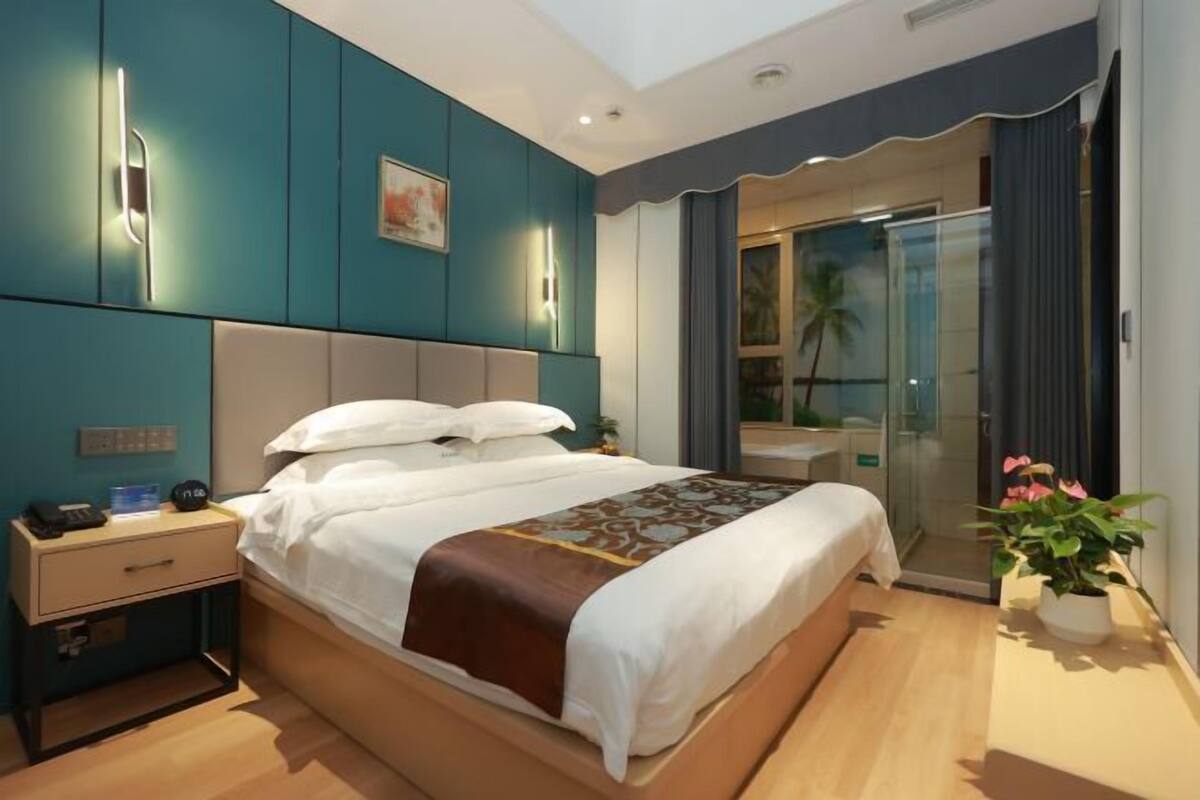 Une chambre d’hôtel moderne avec un grand lit, une table de chevet et une vue sur l’extérieur.